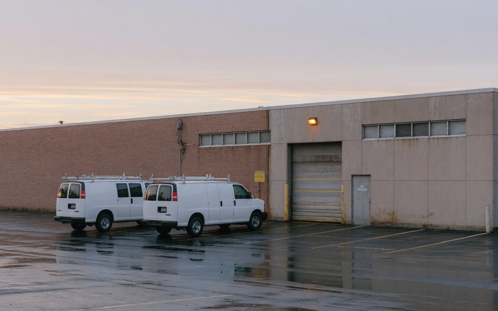 Dawn outside a West Springfield commercial building with two work vans parked side by side